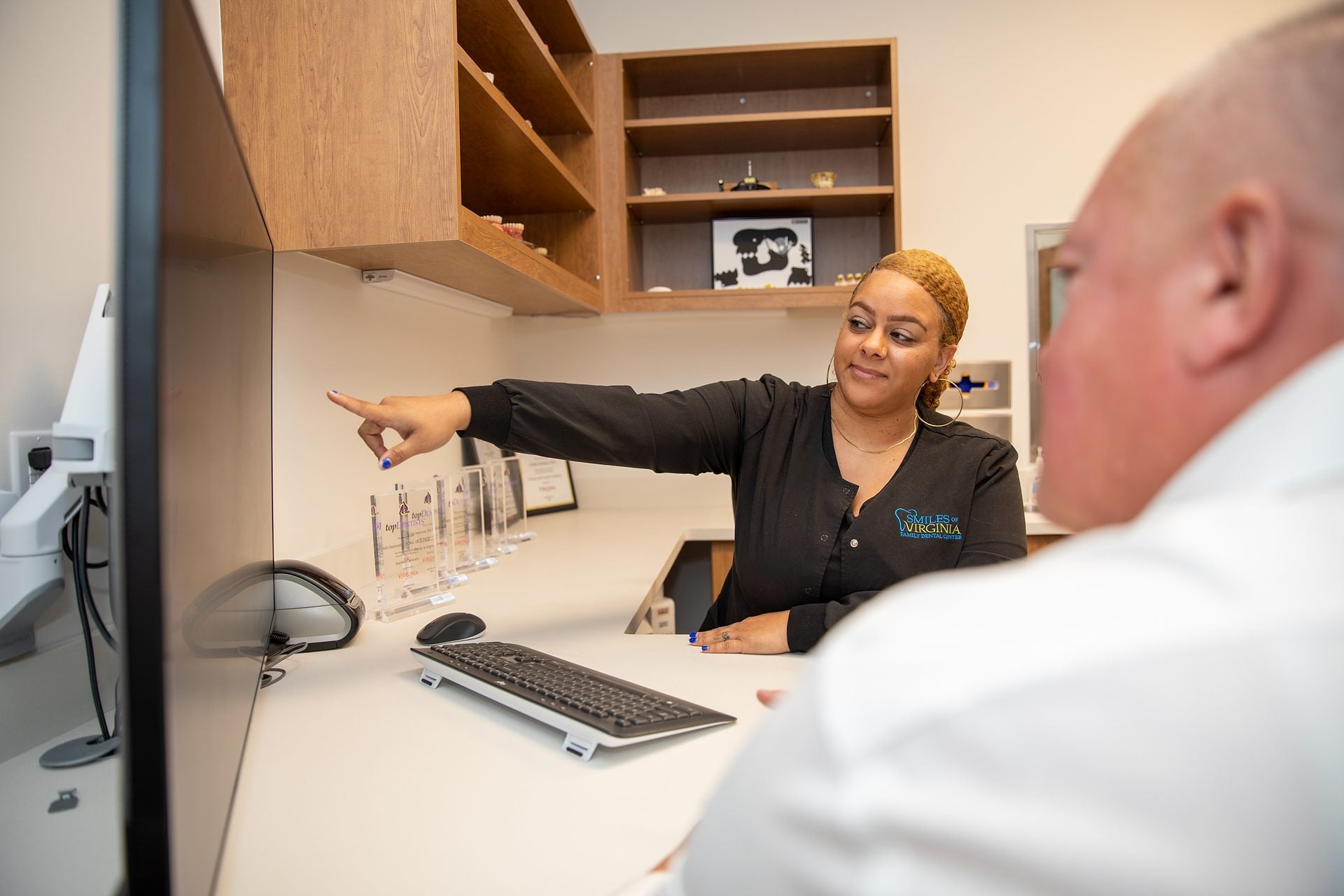 Treatment coordinator explaining treatment options to a dental implant patient in the consultation room
