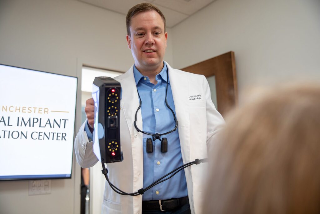 Dr. Niels Oestervemb holding a handheld 3D face scanner used for digital treatment planning