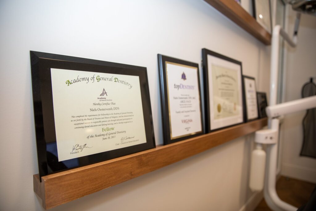 Dr. Niels Oestervemb's Academy of General Dentistry Fellowship certificate and Top Dentist awards on display