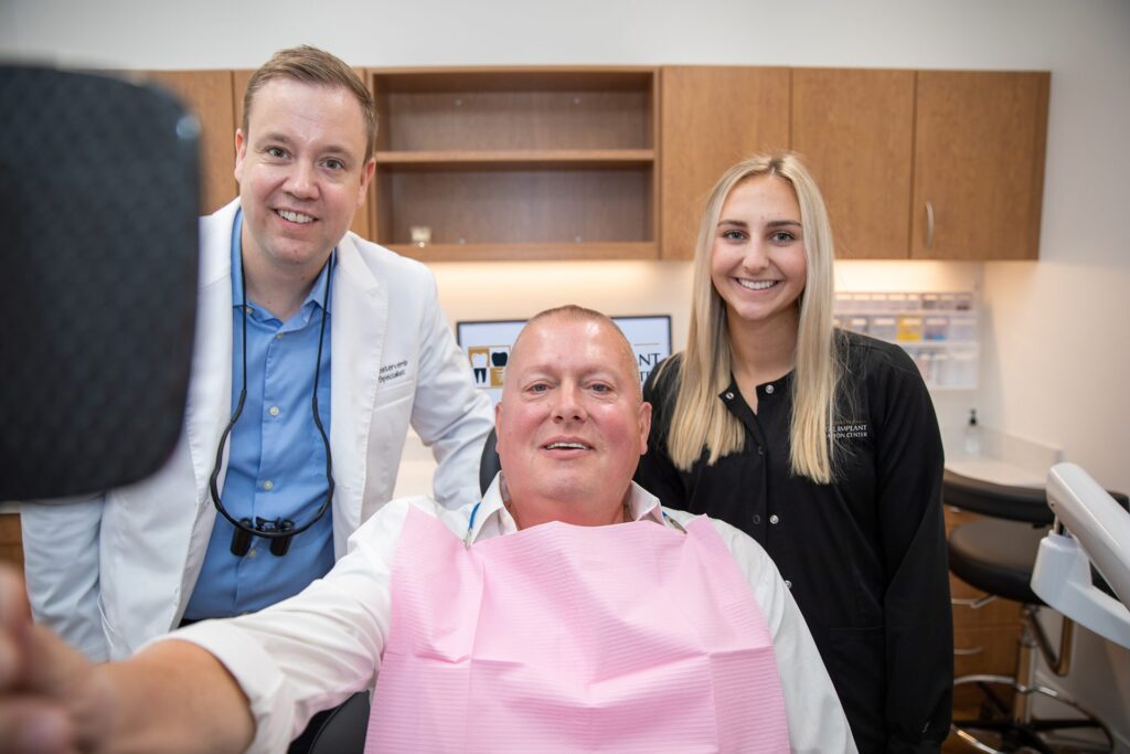 Dr. Oestervemb, a dental assistant and a smiling upper All-on-4 patient in the treatment room
