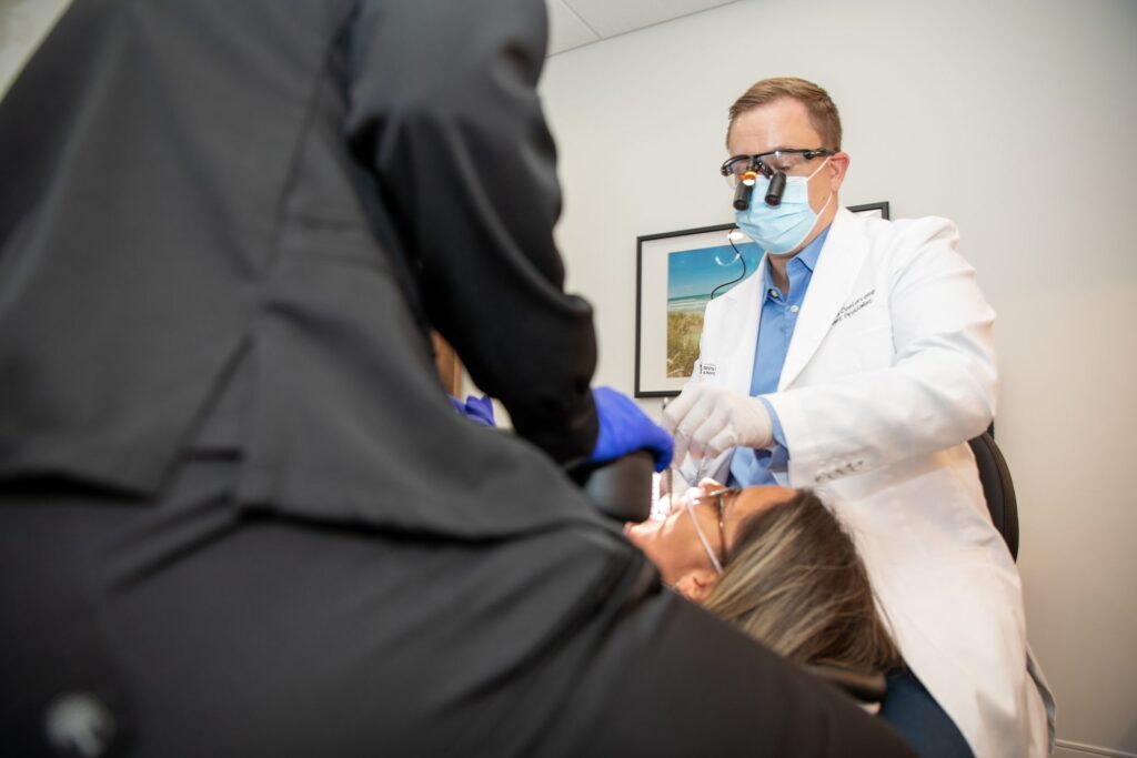 Dr. Niels Oestervemb wearing surgical loupes while treating a patient