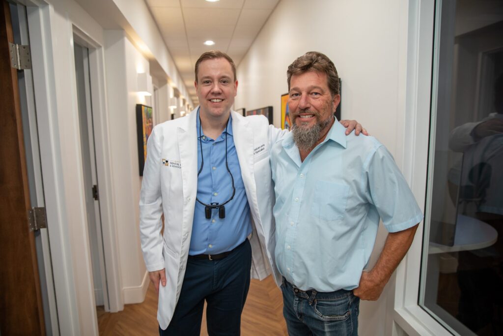 Dr. Niels Oestervemb and his upper All-on-4 patient smiling in the office hallway