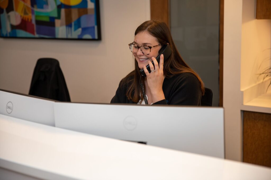 Front desk team member answering the phone at Winchester Dental Implant & Sedation Center