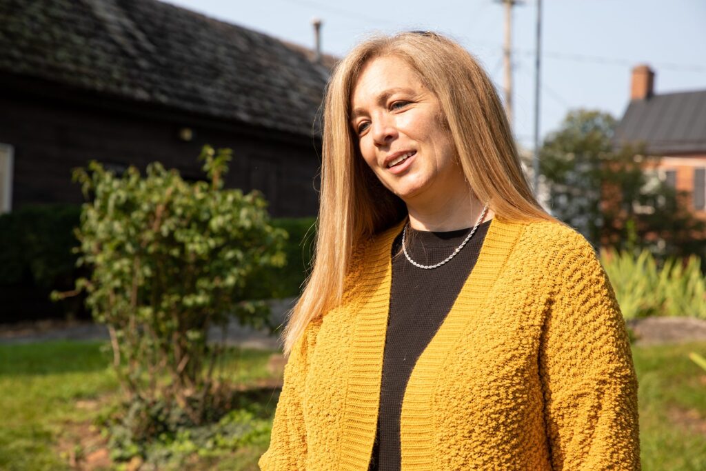Full-mouth rehabilitation patient smiling outdoors after her treatment at Winchester Dental Implant & Sedation Center