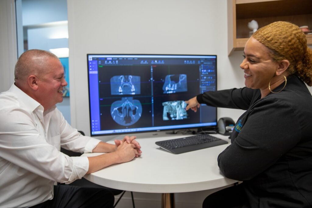 Reviewing bone levels around dental implants on a 3D cone beam CT scan with a patient