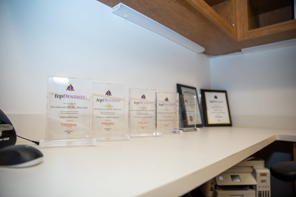 Virginia Living Top Dentists awards for Dr. Niels Oestervemb displayed on a desk