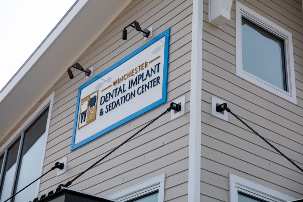 Winchester Dental Implant & Sedation Center sign mounted on the building exterior in Winchester, VA